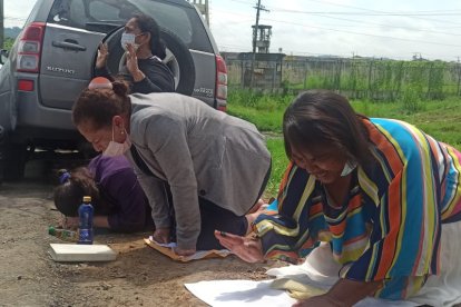 Un grupo de mujeres reza por la seguridad de la cárcel.