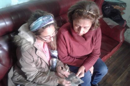 Greta Encalada (buzo rojo) y su hija Mayra Ramírez miran con desconsuelo la fotografía de María Dolores.