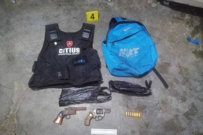 Entre las evidencias halladas estaba un chaleco estilo policial y armas de fuego.