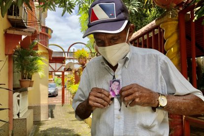 Alejandro Cosme sostiene una foto, fue amigo de la infancia y quien lo acompañó con la guitarra por nueve años.