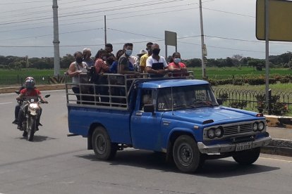 La gente se transporta peligrosamente en baldes de camiones destartalados.
