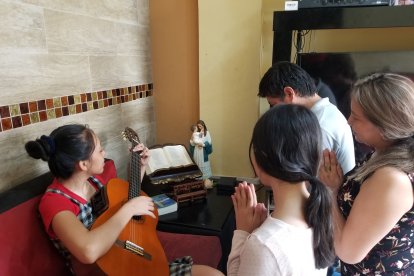 Marisol Naranjo y su familia ofrecen cánticos y oraciones a la Virgen María.