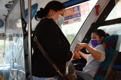 Gissela Rojas se desinfecta las manos luego de tener contacto con cada usuario.