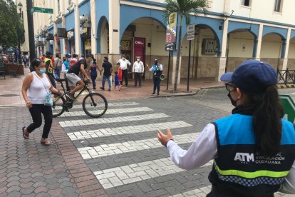 Dos infractores. Una mujer corre apresurada, fuera de la zona de seguridad, mientras un ciclista que venía en contravía por la 9 de Octubre, ingresa a la calle Chile.