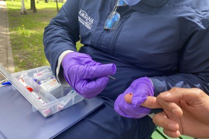 Carlos utiliza una lanceta para extraer la sangre del dedo.
