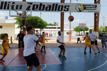 Matías Oyola, Emmanuel Martínez, Fabián Bustos y Javier Burrai jugando un partido de básquet con los chicos de la Fundación Caballito Zevallos.