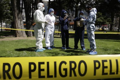Los peritos se preparan para recoger evidencias  en la escena del crimen.