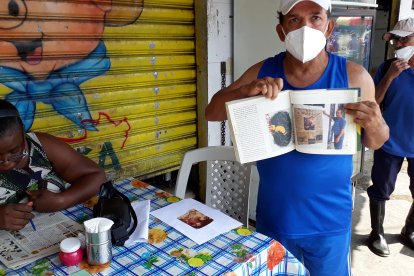 El ex boxeador muestra un libro donde se habla de él.