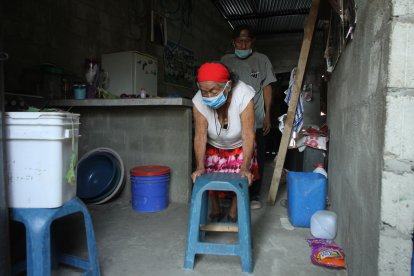 Con este banquito plástico ella se desplaza por toda su casa; es su andador improvisado.