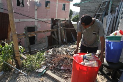 Botellas ‘apiladas’ permanecen en el patio de los adultos mayores. En el fondo se puede constatar el cerco dañado.