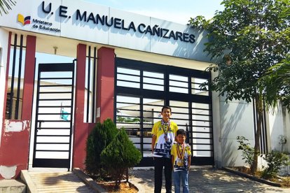 Los dos chicos, al píe de la Unidad Educativa donde estudian en Guayaquil.