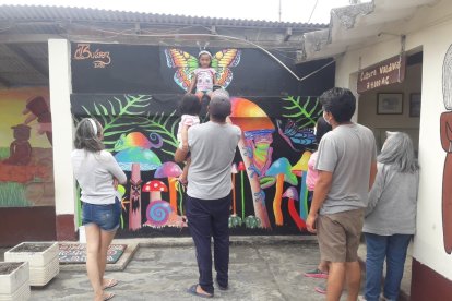 Los turistas se toman fotos en los murales pintados.