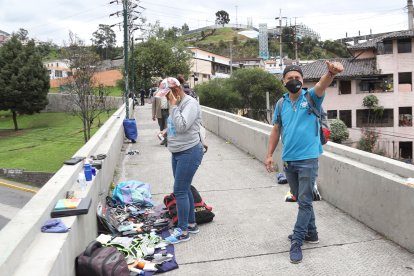 Carlos Eduardo Quintero (azul) vende todo a un dólar sobre el puente de San Roque.