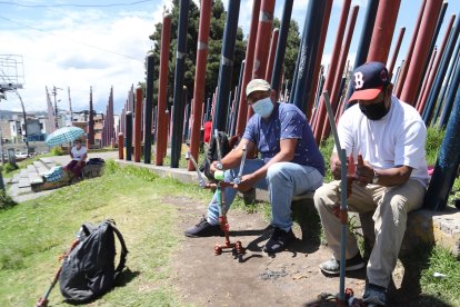 Oswaldo Amaguaña, junto a otro plomero, exhibe su trabajo cerca de los tubos.