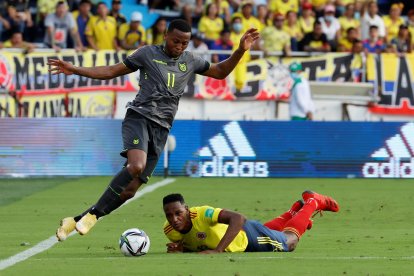 Yerry Mina (d) de Colombia quedó en el piso al intentar marcar a Michael Estrada de Ecuador.