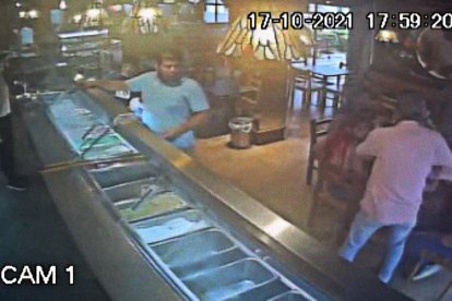 Cámara de seguridad captó el instante en que el delincuente entra y asalta a los comensales. También cuando ocurre el cruce de balas.