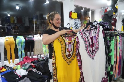 Dunay Cabrera habla entre el susurro y el recelo de la santería mientras arregla la ropa que vende.