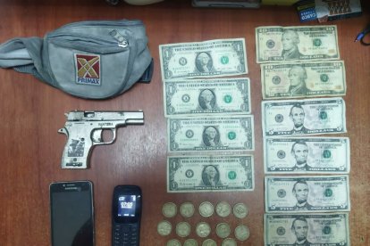 Arma, dinero en efectivo y un bolso de la gasolinera asaltada mostró la Policía como evidencia.