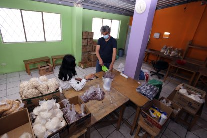 Junto con su hija Ana, el vecino arma las bolsas de alimentos para familias vulnerables.