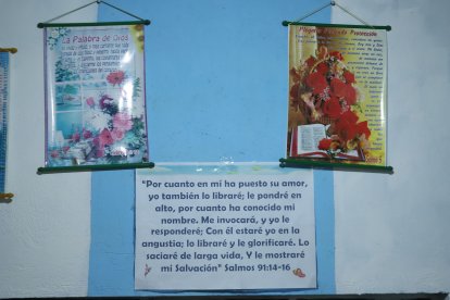 Tiene imágenes religiosas y versículos de la Biblia pegados en la pared de su casa.