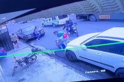 En esta imagen se observa cuando dos  hombres  en moto se acercan a los policías.