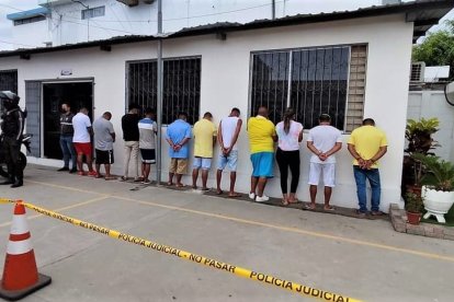 Los trece detenidos puestos contra una pared del cuartel policial.