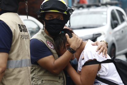 La hija mayor del reciclador Néstor Pacheco fue consolada por bomberos.