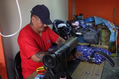 Cruz López cose los pedazos de tela que van adheridos a los coches o corrales de niños.
