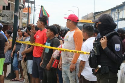 Moradores del sector y transeúntes miran la escena del crimen, que fue acordonada por la Policía.