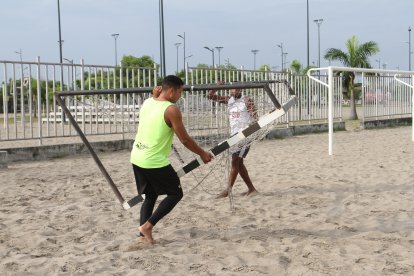 Jefferson Domínguez y Michael Quiñónez llevando el arco para entrenar.