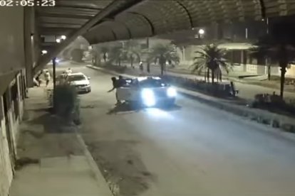 Los sicarios bajan del auto y van hacia las víctimas.