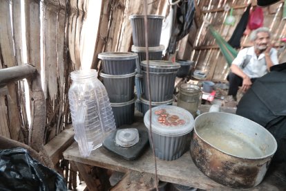 En una mesa de madera reposa su licuadora, los centavos que se hace y las tarrinas de comida que le regalan.