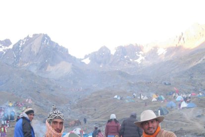 El argentino (izquierda) comparte con comuneros en Perú durante sus viajes como sacerdote Krihsna