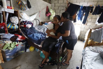 Una de las hermanas de la víctima da consuelo a su madre, que abraza el peluche de su hija fallecida.