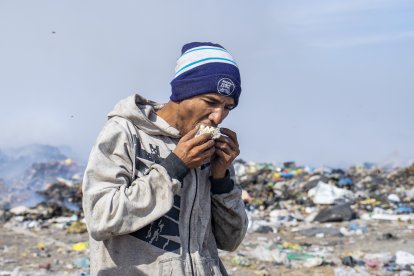 Unos recicladores aprovechan cierto alimento que hallan entre los desperdicios.