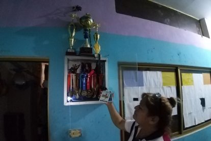 La progenitora enseña las medallas y trofeos que ganó su hija como bailarina.