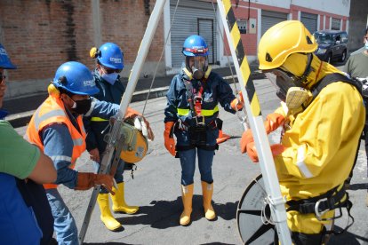 Los trabajadores están sujetos a un trípode de metal para bajar a los pozos, llamado línea de vida.