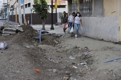 Los peatones tienen que caminar esquivando los escombros que quedan en el filo de la calle.