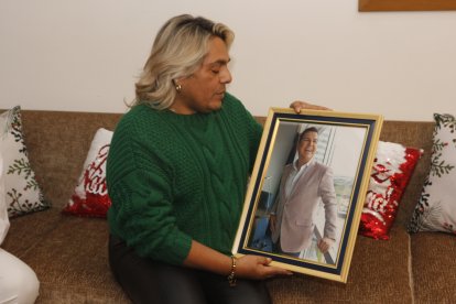 Rómulo sosteniendo el cuadro con la foto de su amigo.