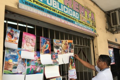 Daniel Dumes, propietario de una imprenta, acomoda varios modelos de calendarios con los que busca atraer clientes.