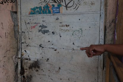 La puerta  presenta 21  orificios de proyectil. Los asesinos dispararon desde afuera.