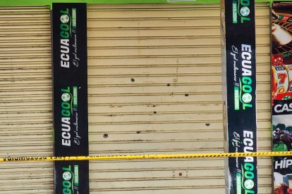 Las huellas de los balazos en la puerta del local.