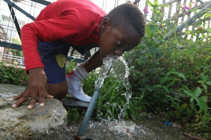 Los ‘pelados’ se refrescan de una llave de  agua que está en el piso y cerca al estero.
