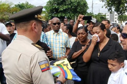 El general Fausto Olivo entregó el estandarte nacional a Stephania Arroyo, esposa del policía asesinado.