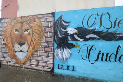 Las imágenes de un águila y un león están dibujadas en la pared de ingreso a la urbanización.
