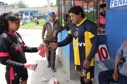 El vocal revisa  las manos de Elizabeth Vizhñay previo a su ingreso a la cancha.