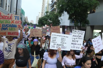 Las asistentes llevan carteles para levantar su voz.