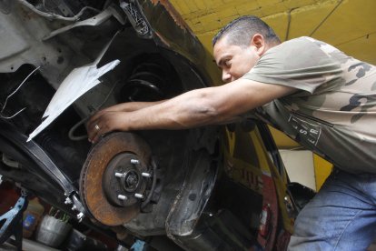Jesús Castillo, quien labora en un taller mecánico, arreglaba el tren delantero de un auto.