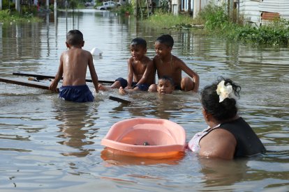 En flotadores o balsas, los habitantes de Milagro se movilizan por las lluvias.