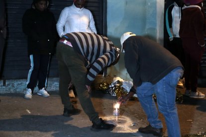 Parientes del taxista asesinado en la parte externa encendieron una vela y la colocaron en donde quedó su cadáver.